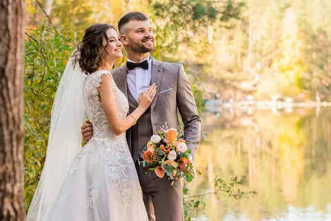 A couple sharing a happy moment beside a lake (illustrative image)